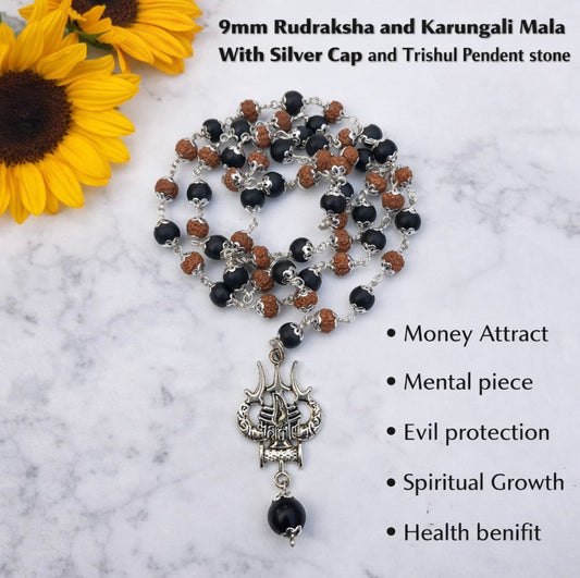 Mala necklace with silver cap and Trishul pendant on a marble surface with sunflowers.