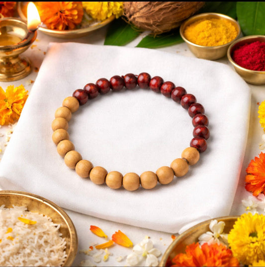 Wooden beaded bracelet on a white cloth with flowers and spices in the background