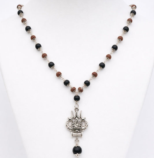 Necklace with black and brown beads and a silver pendant on a white background